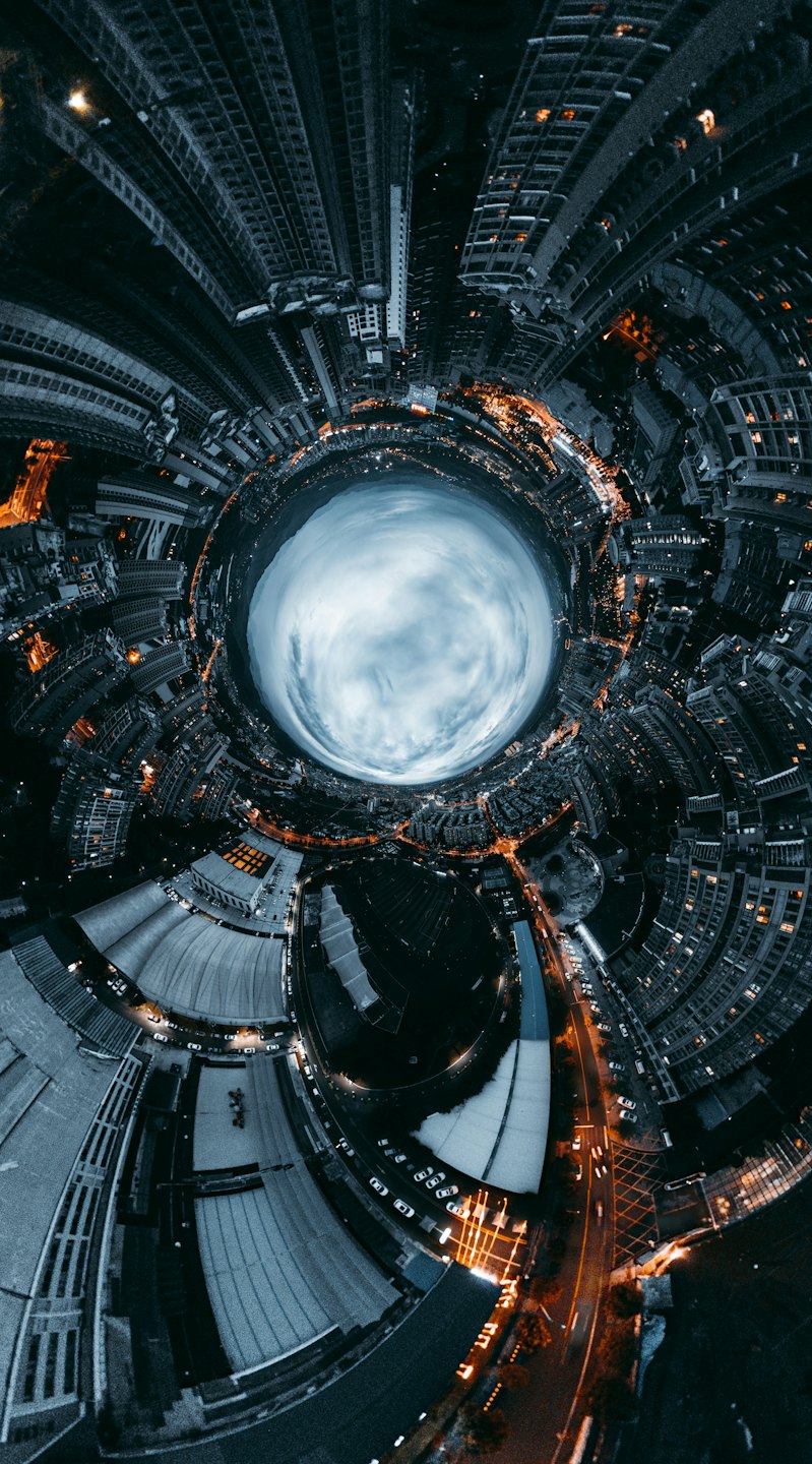 Luftaufnahme einer leuchtenden Stadt bei Nacht mit beleuchteten Straßen.