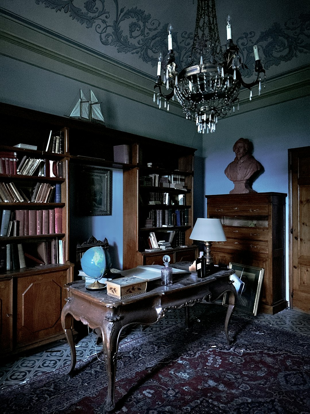 Antike Bücher säumen die Regale eines historischen Studierzimmers.